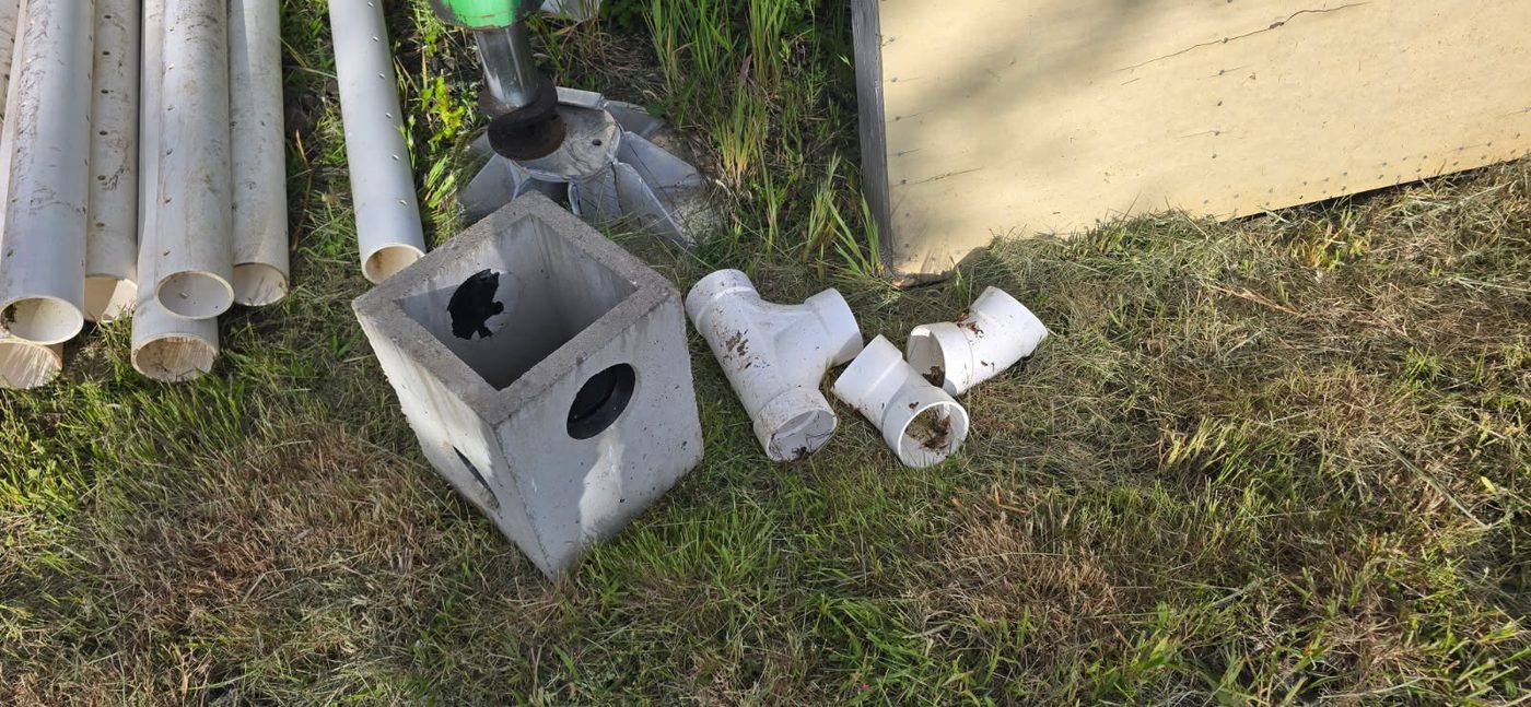 Concrete distribution box and PVC fittings staged on site, May 30, 2026